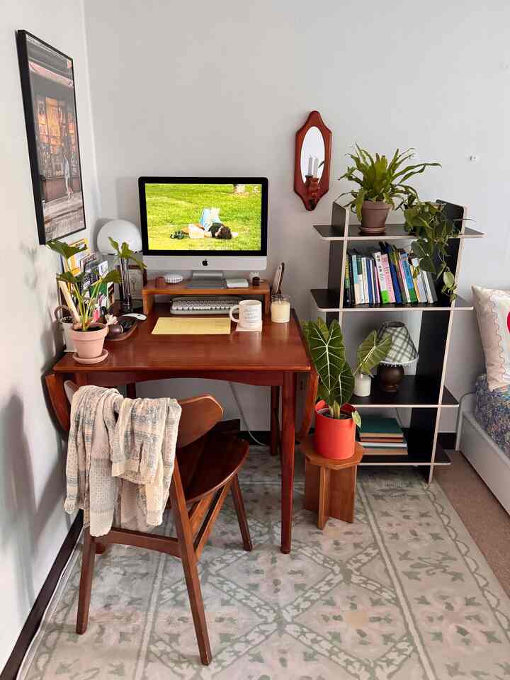 温かみのある木目調と植物が調和したワンルームのホームオフィス、シンプルで自然なインテリア