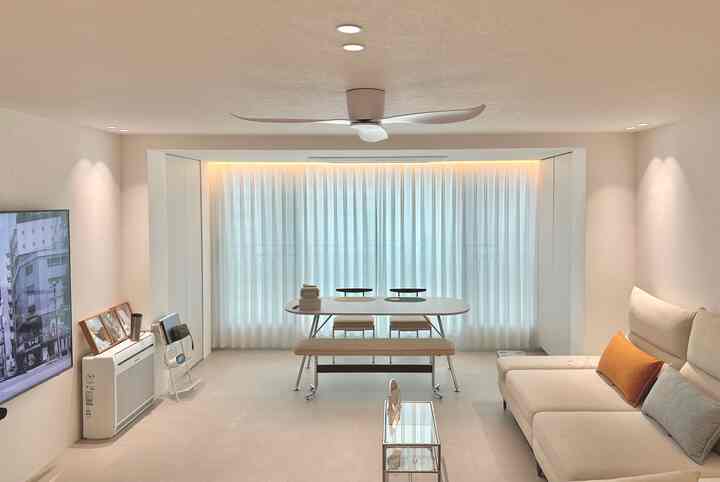 アイボリーと白を基調としたリビングとダイニングスペース、シーリングファンと機能的な家具が調和した印象的なインテリア
