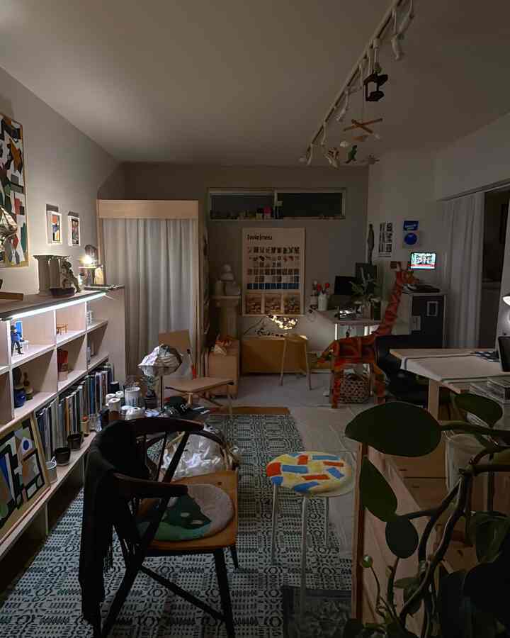 ナチュラルカラーと木目調の1LDK書斎、書棚とラグが配置された居心地の良い一人暮らしのインテリア