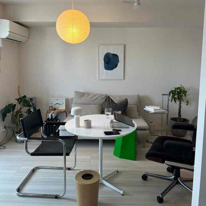 White and wood tone living room featuring modern furniture and home office elements in a clean design