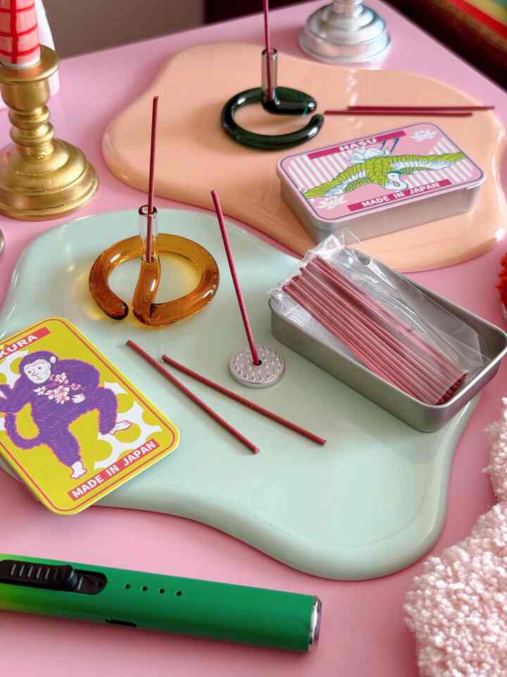 パステル調のテーブルにカラフルな和モダンスタイルのインセンスホルダーとトレイが配置された雰囲気のあるインテリア