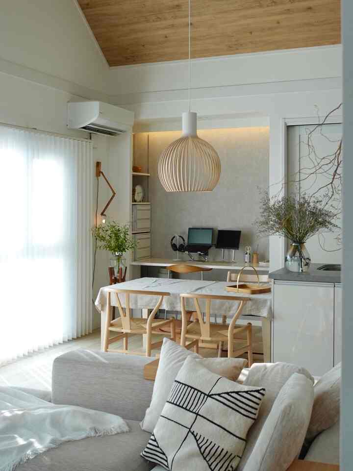Beige and wood tone living and dining room featuring a natural, clean home office setup