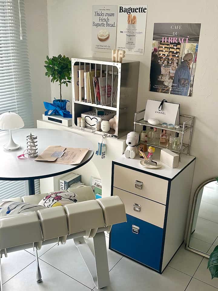 Modern living room in white and blue tones featuring a bookshelf and chest of drawers with a clean aesthetic