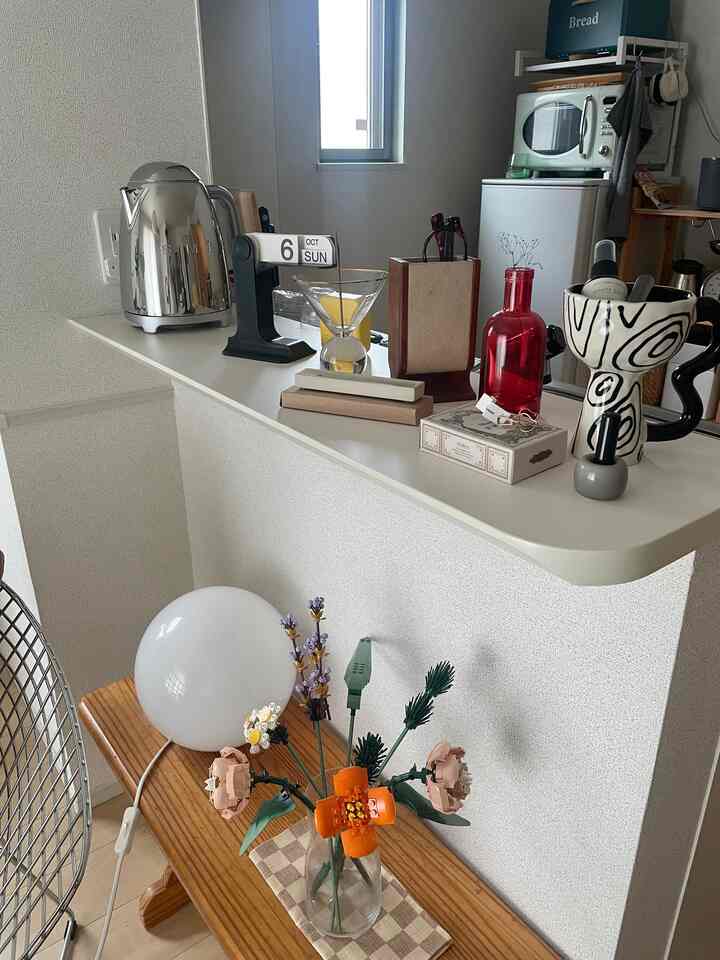 White and natural wood-toned kitchen corner featuring assorted decor and plants with cozy atmosphere
