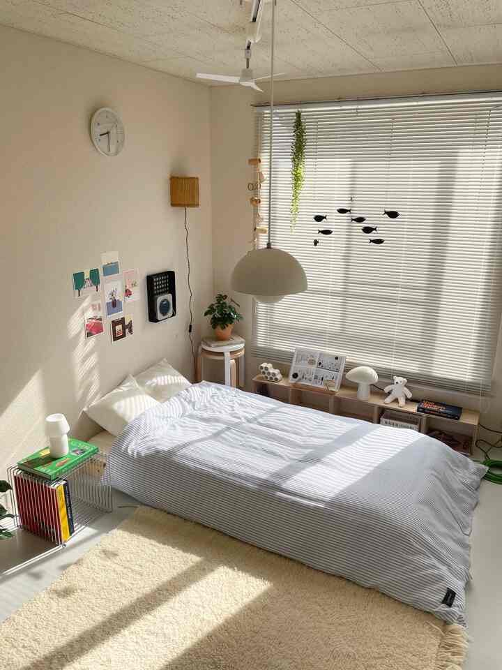 Natural-toned bedroom featuring striped bedding and beige rug with cozy atmosphere