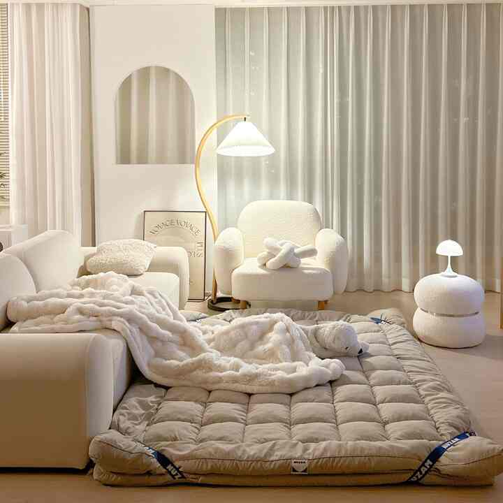 ホワイトとベージュの色調のリビング、柔らかなソファとアームチェアが配置された雰囲気のあるナチュラルモダンなインテリア