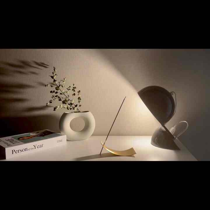 A simple interior desk featuring white and black monotone lighting and objets with soft shadows