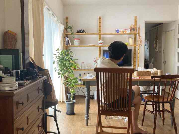 ナチュラルなブラウンウッド調のダイニングルーム、木製のテーブルと椅子、植物、DIYの棚が配置された雰囲気のあるインテリア