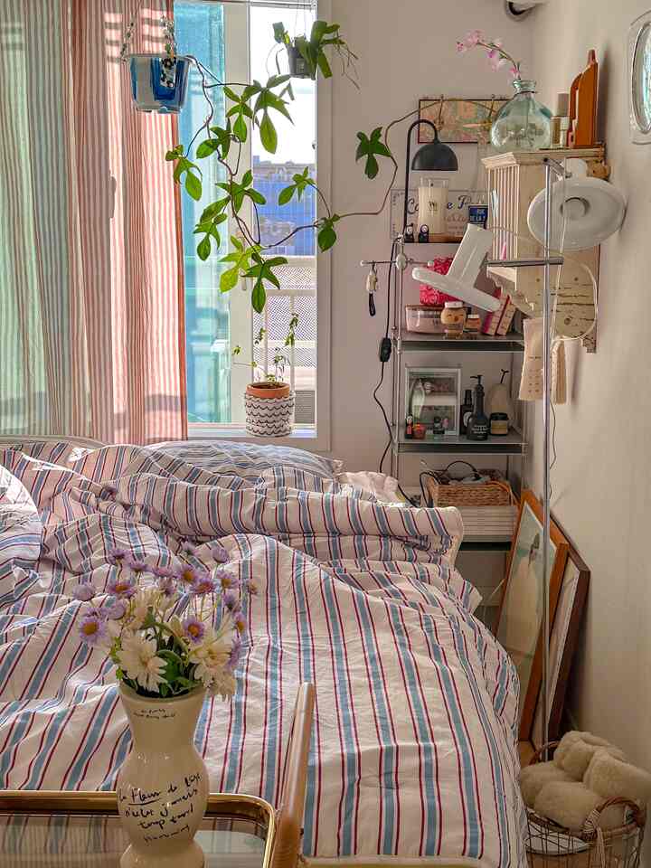 White and brown toned bedroom featuring natural light and striped bedding creating a cozy atmosphere