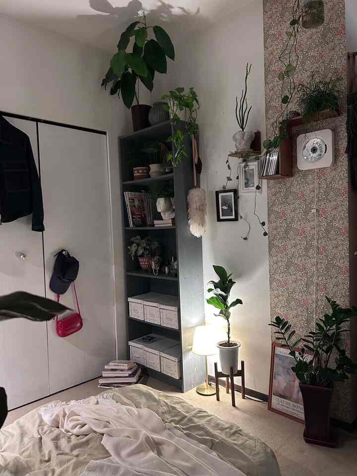 ナチュラルな白とベージュの寝室、複数の植物が配置され、落ち着いた雰囲気のインテリア