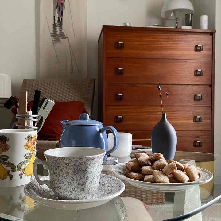Brown wood tones and lavender accents in a single household home cafe space, featuring vintage furniture and cozy tea time atmosphere