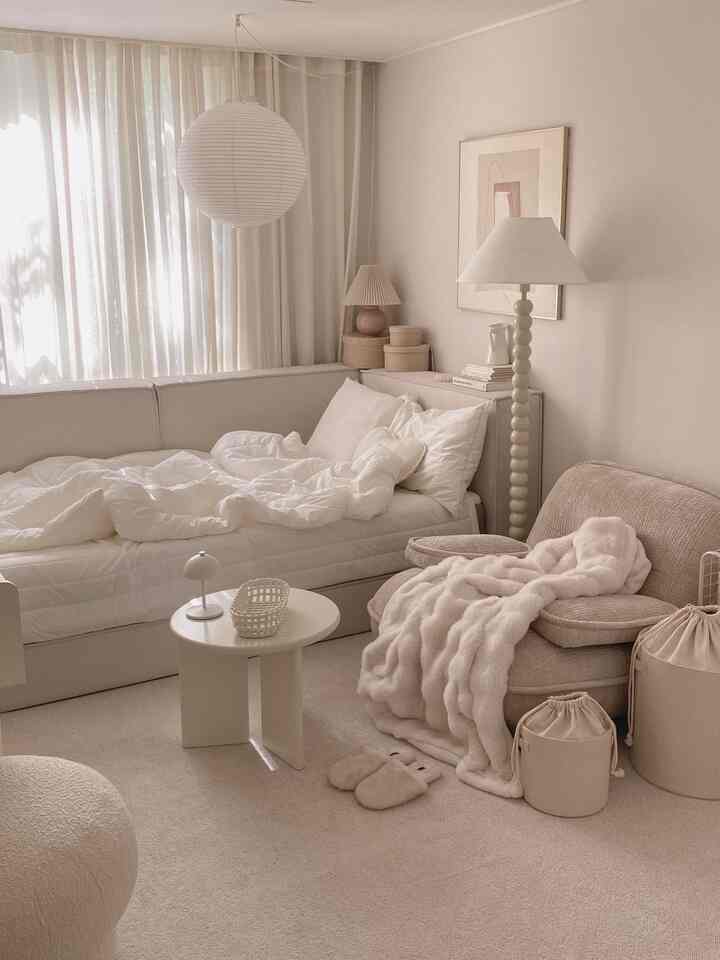 ベージュとホワイトの色調のリビング、ソファとベッドが配置された居心地の良いナチュラルモダンなインテリア