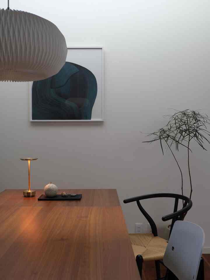 Brown wood tone dining room featuring a dining table and black armchair with a minimal and natural atmosphere