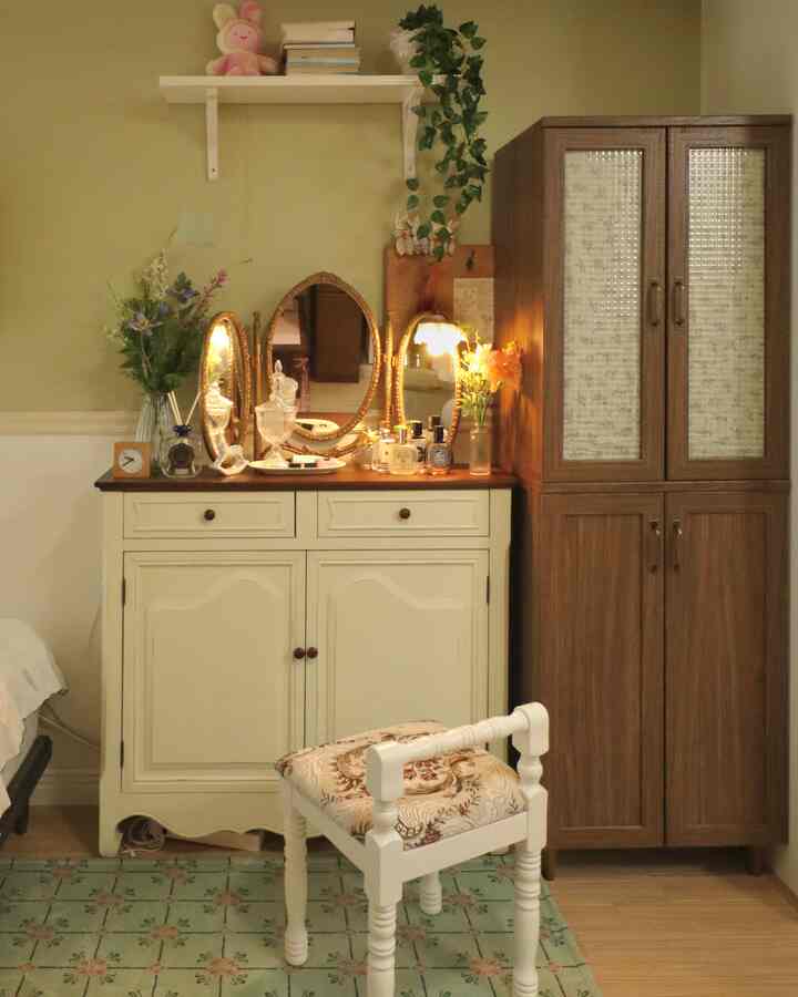淡いオリーブ色の壁とクリーム色の化粧台、ゴールドのヴィンテージミラーが調和した7坪ワンルームの雰囲気ある化粧台スペース