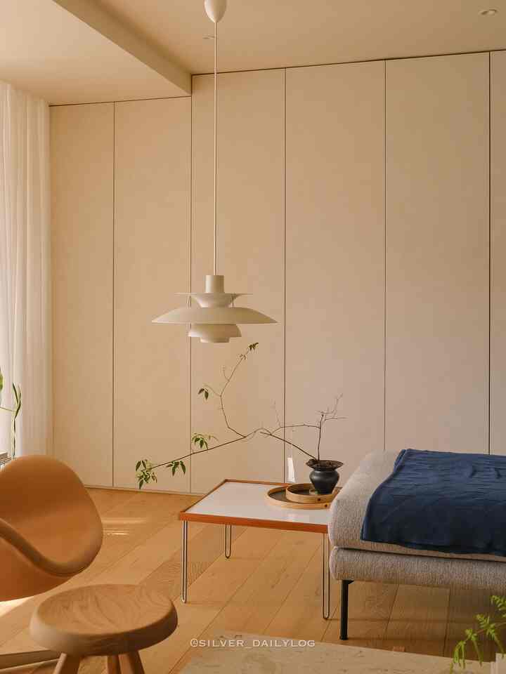 ベージュとウッドトーンのリビング、ルイス・ポールセンPH5照明とミッドセンチュリーモダン家具が配置された自然でモダンな空間