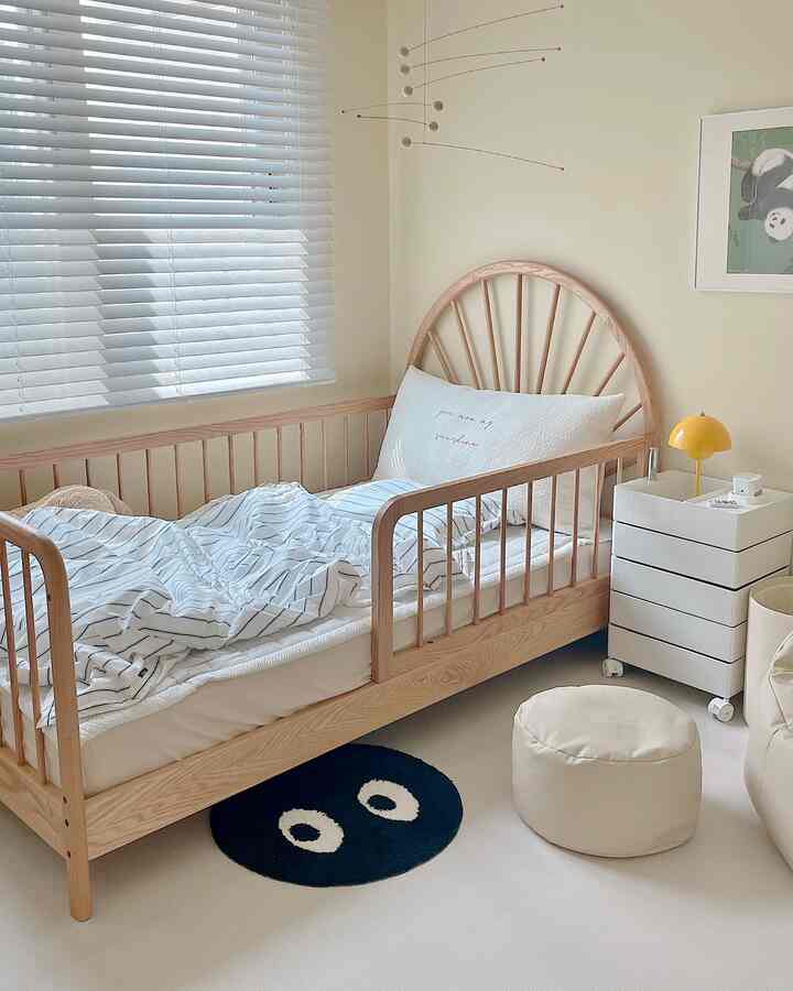 ナチュラルカラーの木目調の子供部屋、木製キッズベッドと白いブラインド、サイドテーブルが配置された清潔感のある空間