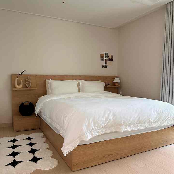 A simple and natural bedroom in wood tones and white colors, featuring a large bed and decorative objets creating a serene atmosphere