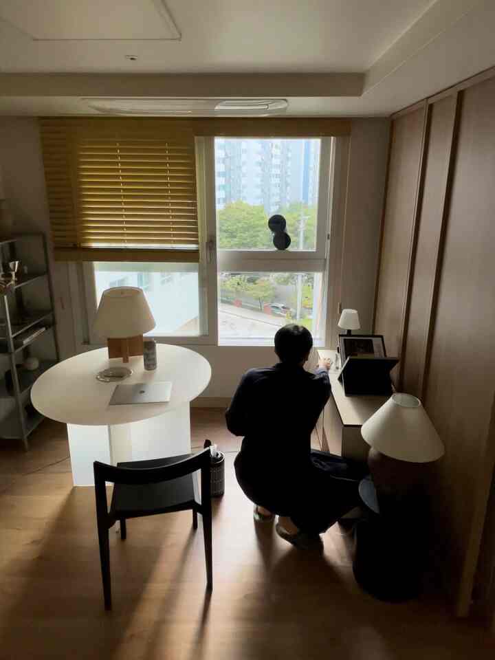 木目調とホワイトが調和するワンルームのダイニングスペース、黄色のウッドブラインドとミニマルな家具が配置された落ち着いた空間