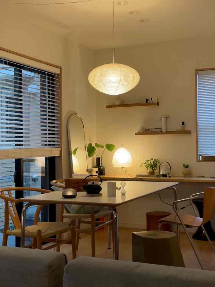 暖かみのあるナチュラルモダンな二人用ダイニング、木製チェアとペンダントライトが配置された雰囲気のある空間