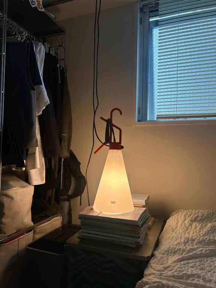 White and natural toned studio apartment bedroom featuring indirect lighting with a cozy, simple atmosphere