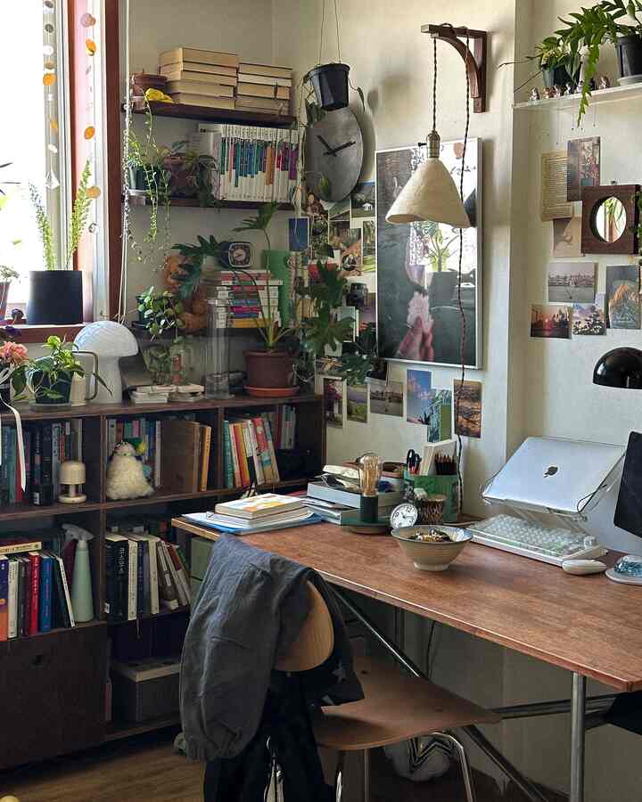 木目調の家具と多様な植物が配置された狭くて居心地の良いホームオフィス兼書斎スペース