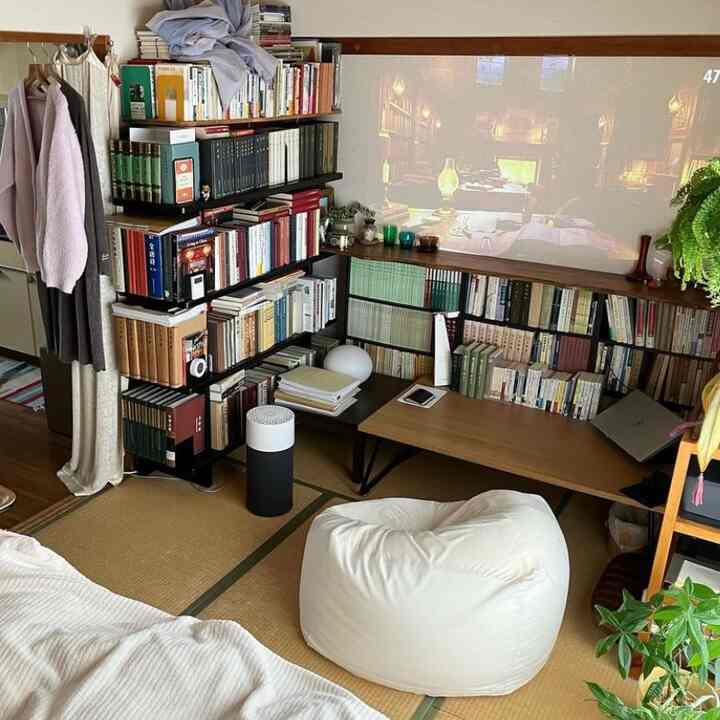 ナチュラルな木目調と白ベージュの和風座敷リビング、ビーズクッションと本棚が配置された雰囲気のあるインテリア