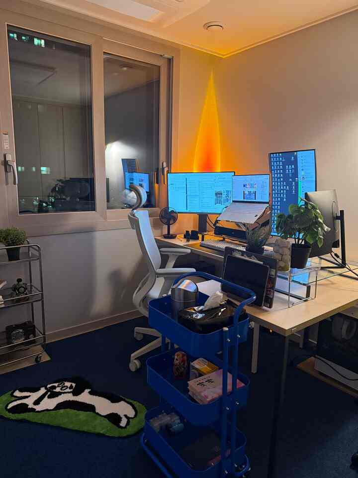 ブルーのカーペットとホワイトの家具が調和するホームオフィス、コンパクトで整頓された作業空間