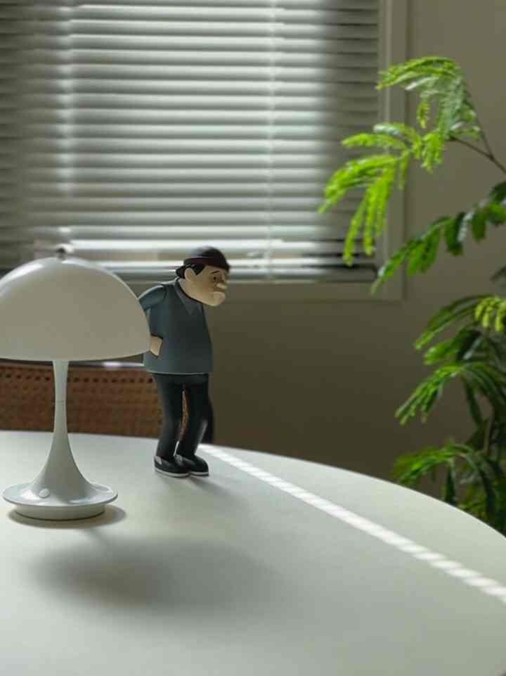 白を基調としたダイニング、中央に白いテーブルランプとモダンなテーブルマットが置かれた清潔感のあるインテリア