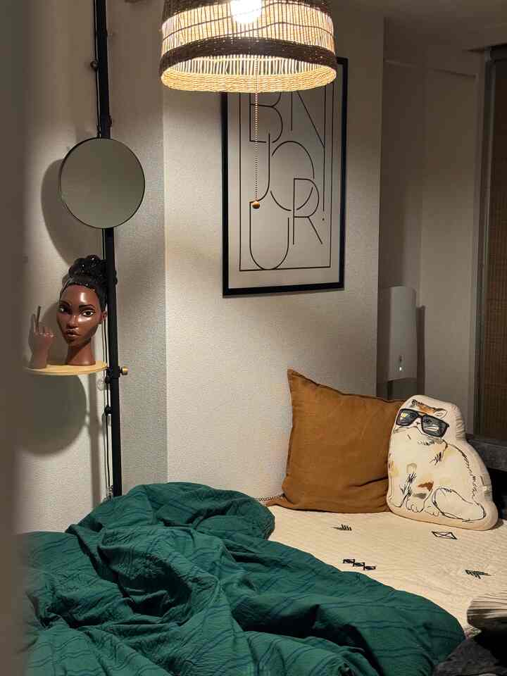 Natural toned bedroom featuring pendant light and cat cushion with cozy, minimal atmosphere