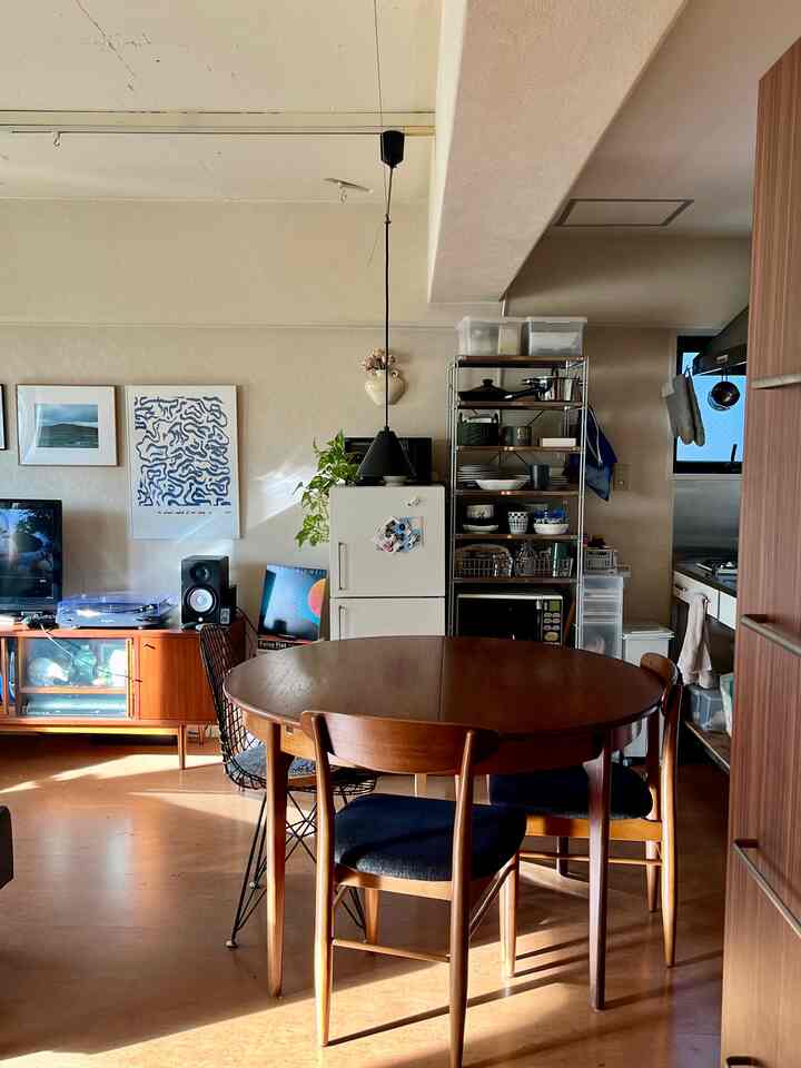 暖かみのあるブラウン調のダイニング、丸いダイニングテーブルと椅子が配置されたレトロな雰囲気の空間