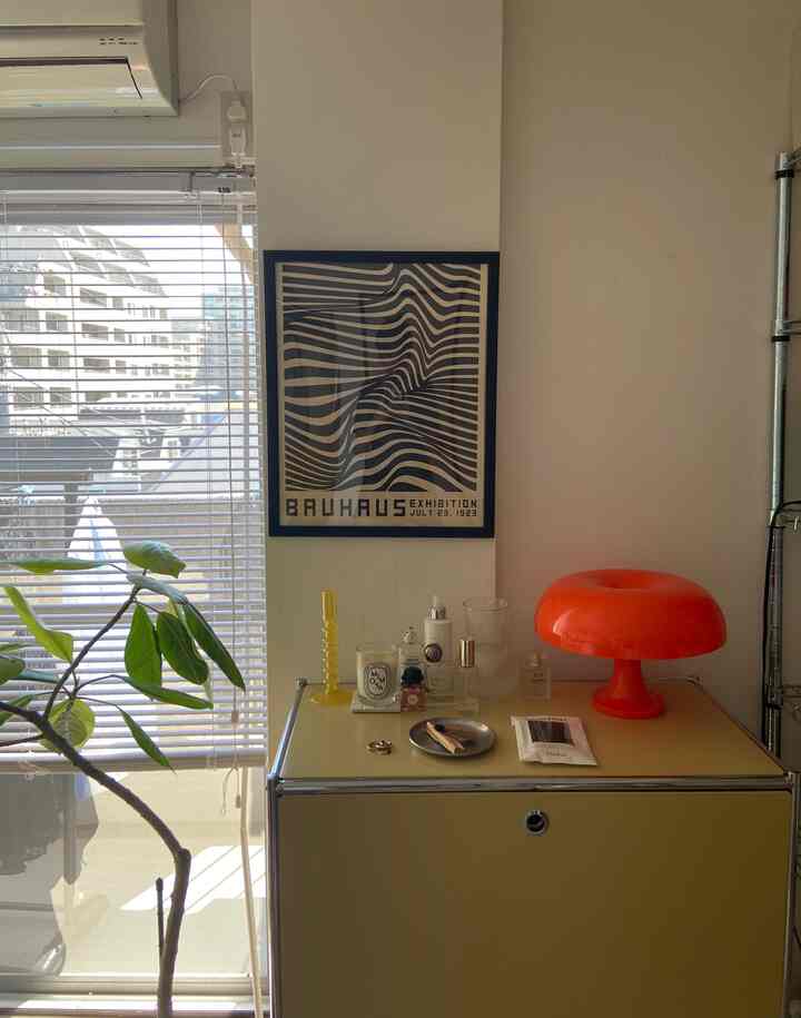 Mid-Century Modern living room with yellow storage cabinet and orange mushroom table lamp, featuring home decor accessories and plants