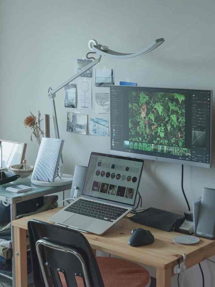 ナチュラルカラーのホームオフィス、木製デスクとモニター、ノートパソコンが配置されたシンプルな作業空間