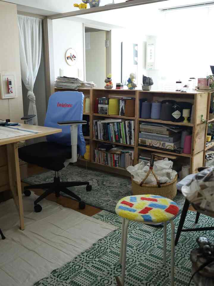 明るいナチュラルトーンのホームオフィス空間、木箱のキャビネットと本棚が配置された温かみのある作業スペース