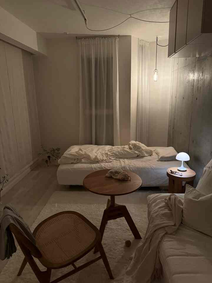 Natural modern bedroom with white walls and light brown furniture, featuring a cozy nighttime atmosphere