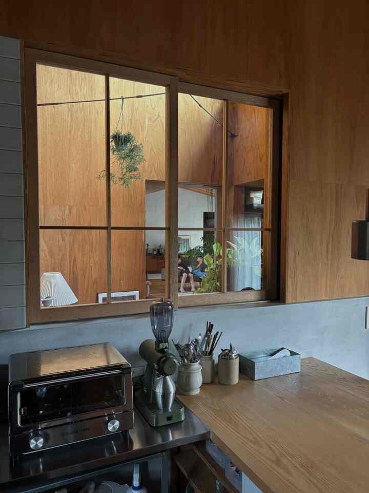 木目調の壁とテーブルがあるキッチン、グラインダーとオーブントースター、整頓されたカトラリーが配置された雰囲気のあるおうちカフェ空間