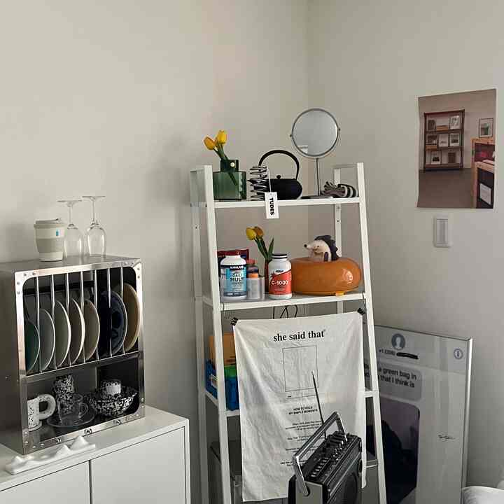 White and wood tone kitchen featuring IKEA metal shelves and stainless steel kitchen rack with neat storage design