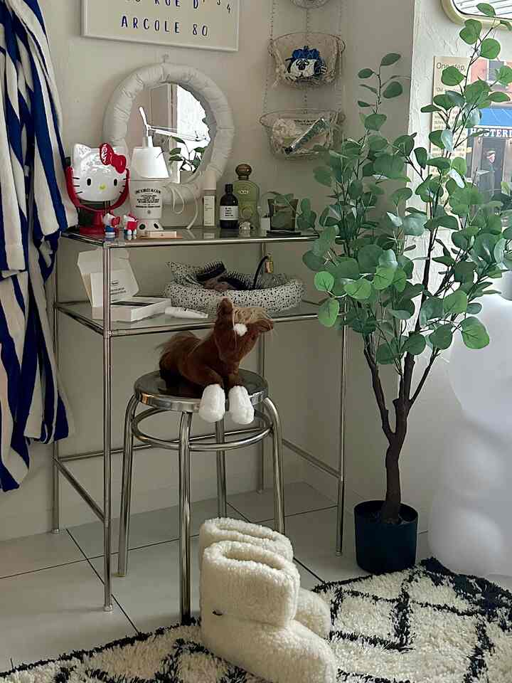 White and green toned balcony space featuring stainless vanity and stool with plants, creating a cozy interior