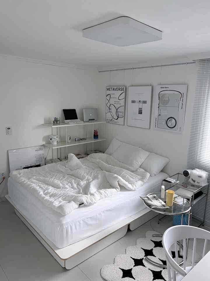 ホワイトトーンの寝室、シンプルなベッドとポスター、ホワイト家具が配された雰囲気のあるインテリア