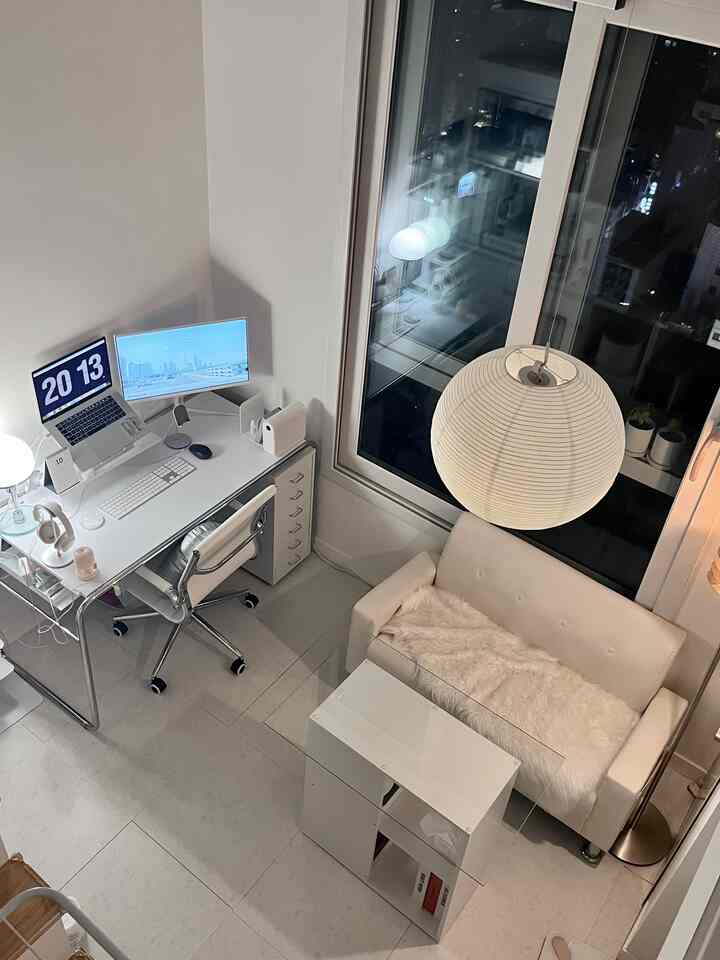 白を基調としたワンルームの作業スペースとソファが配置されたモダンなコンパクトインテリア