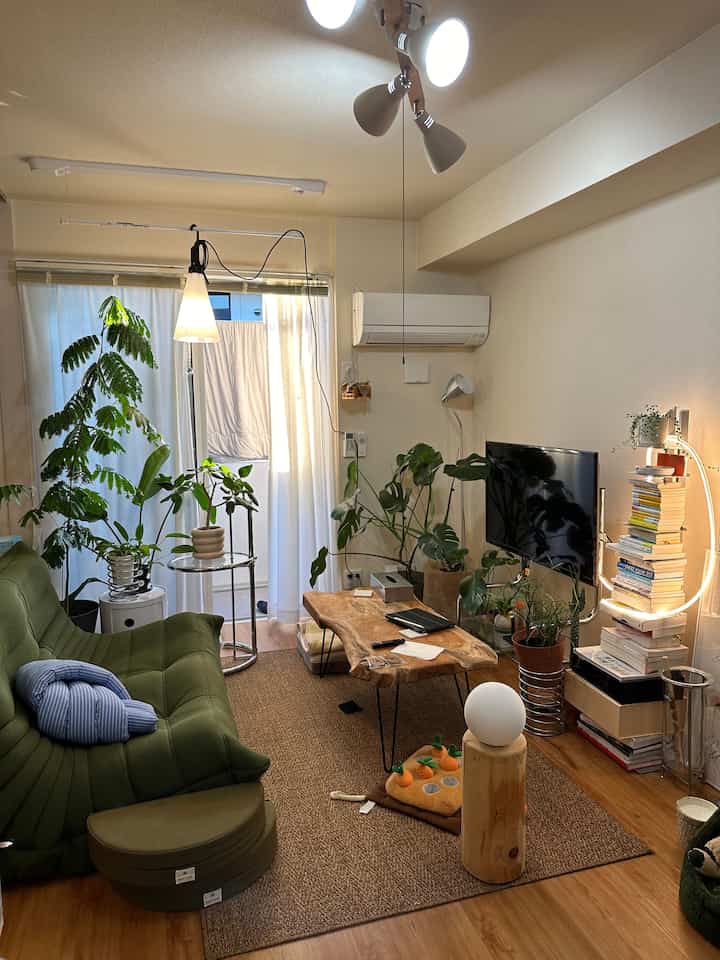 ナチュラルカラーとグリーンのリビング、自然な木製のコーヒーテーブルと柔らかなトーゴソファが配置された温かみのある空間