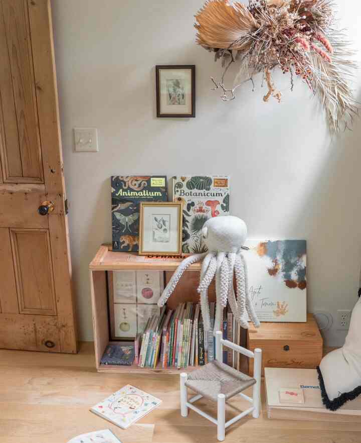 ナチュラルカラーの子供部屋、木製のドアとおもちゃ収納が配置された温かみのある心地よい空間