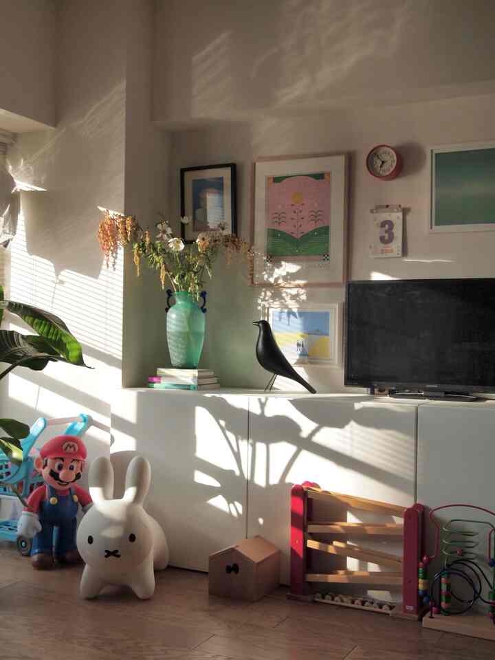 White and wood tone kids' room with curtain light casting shadows on the wall, creating a warm atmosphere