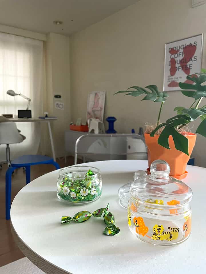 白を基調とした1LDKの空間、ラウンドテーブルにはキャンディジャーと植物が置かれた雰囲気のある北欧スタイルのインテリア