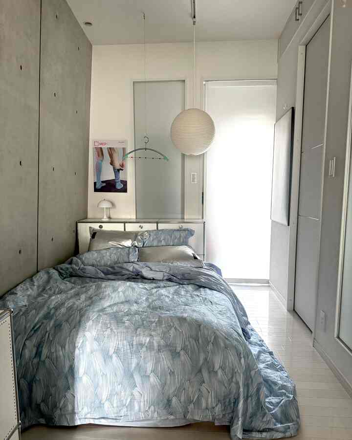 白と青の配色が印象的な寝室、中央に青い柄のベッドリネンがあるモダンで清潔感のあるインテリア