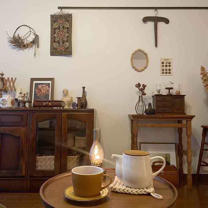 木目調と白を基調としたカフェ風のダイニングスペース、ヴィンテージのキャビネットとテーブルにティーポットとカップが配置された印象的な空間