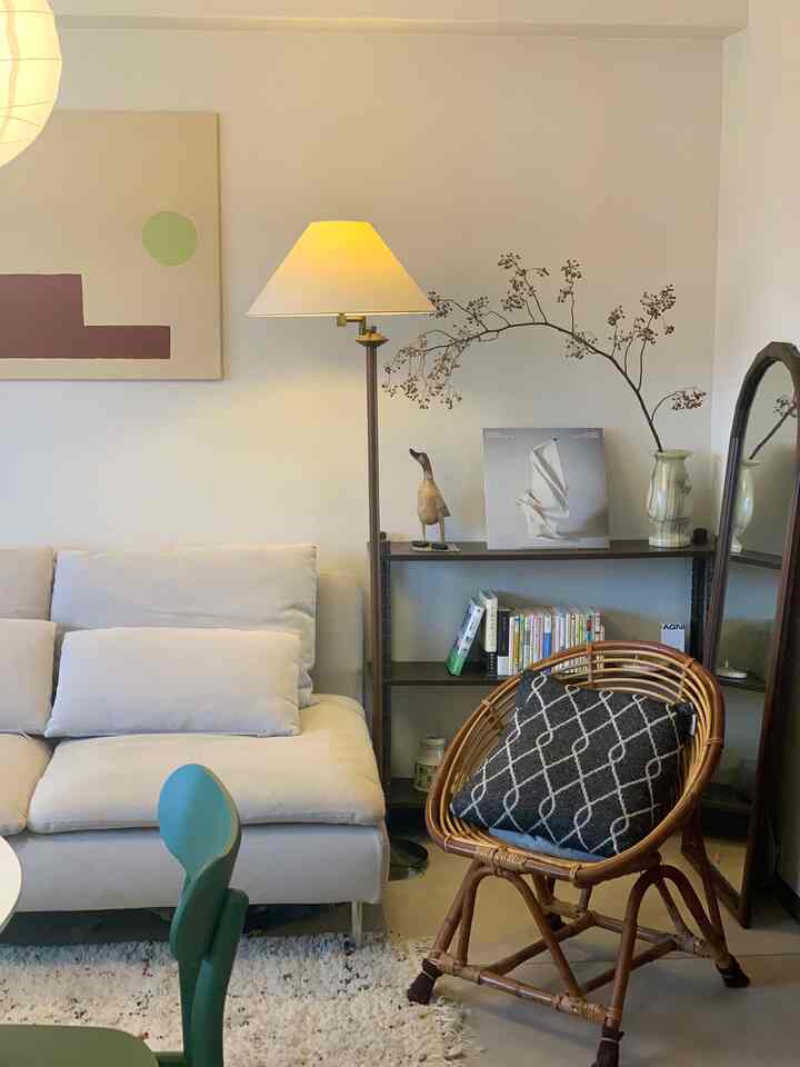 ベージュとナチュラルカラーのリビング、ベージュのソファとラタンチェア、フロアランプが温かみのある雰囲気を演出