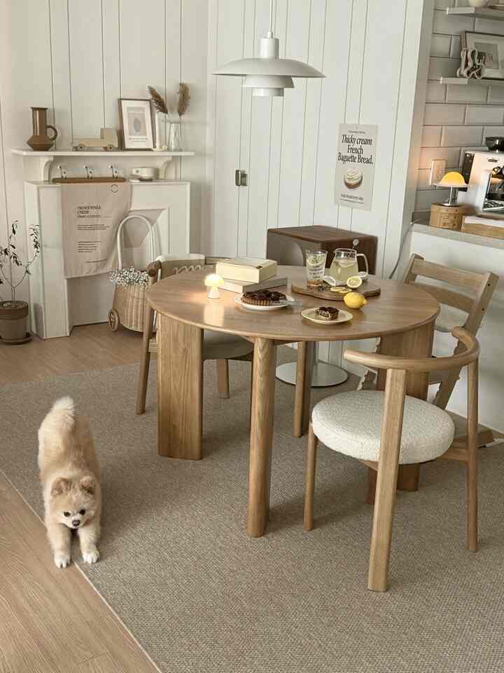 ナチュラルなブラウンウッドのダイニングルーム、円形の無垢材テーブルと椅子が印象的なホームカフェ空間を演出