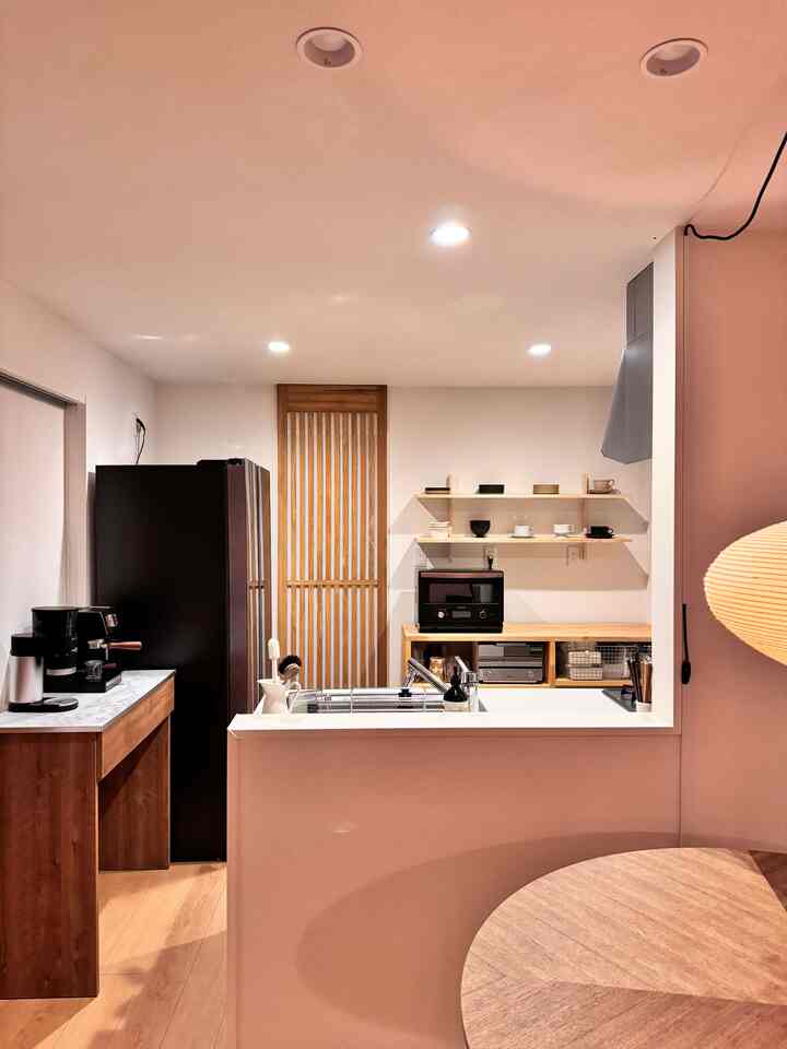 Cozy Wa-Modern kitchen with warm wood tones and monotone colors featuring a round dining table and black appliances
