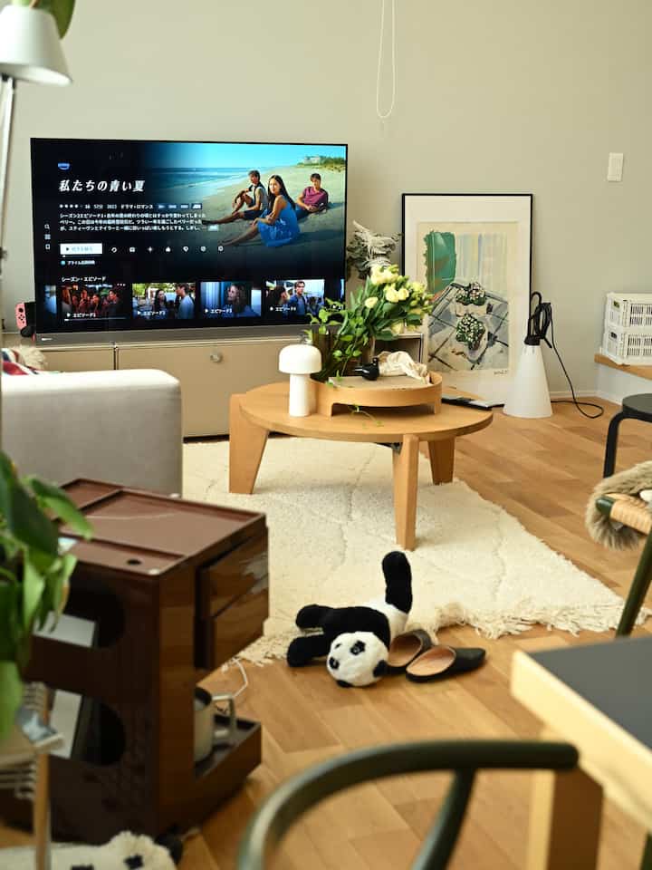Natural tone living room featuring a round wooden coffee table and TV stand with a cozy atmosphere