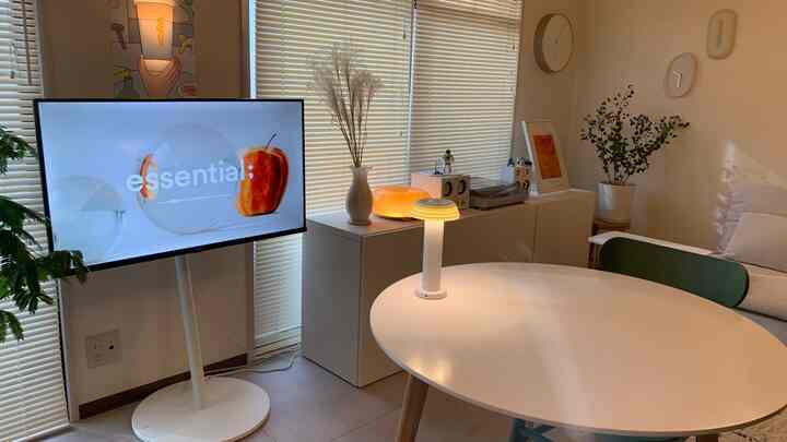 ナチュラルな色調のダイニング、回転式テレビ台と丸いダイニングテーブルが配置された雰囲気のある空間